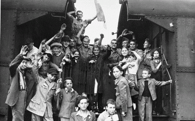 Jewish children at the Buchenwald Displaced Persons camp wave goodbye