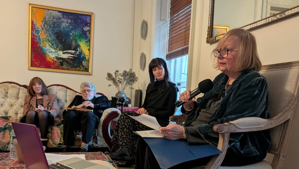 Helene Bass Wichelhaus presenting, looking on Mark Sossin and Janka Thormos who organized the event